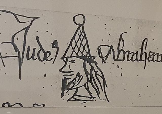 Darstellung des „Juden Abraham“ in einem Verzeichnis des Zerbster Kollegiatstifts St. Bartholomäi aus dem 15. Jahrhundert.    Foto von einer Ausstellungstafel im Museum der Stadt Zerbst.